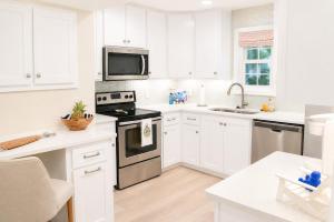 a white kitchen with a stove and a microwave at Bright Coastal Condo in Saint Simons Island