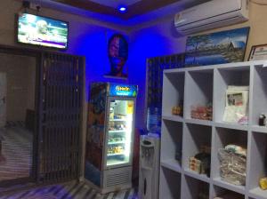 a room with a refrigerator with a painting of a man at RockView Hotel in Tongo