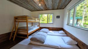 a room with three beds and a bunk bed at 暮らす宿ソラプチ Sorapchi Cabin in Ochiai