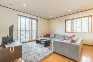 a living room with a couch and a tv at Kiseki in Kutchan