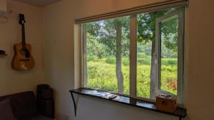 a window in a living room with a guitar at 暮らす宿ソラプチ Sorapchi Cabin in Ochiai