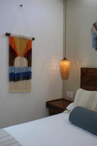 a bedroom with a white bed and a lamp at Hotel Boutique Kasa Sara in San Patricio Melaque