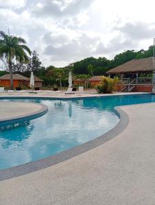 a swimming pool with blue water in a resort at La Galante, studio proche plage privée in Grand-Bourg +18 photos
