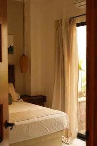 a bedroom with a bed and a window at Hotel Boutique Kasa Sara in San Patricio Melaque