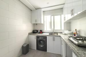 a white kitchen with a washing machine in it at Reda Appartements Al Hoceima in Al Hoceïma