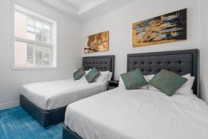 ein Schlafzimmer mit zwei Betten und einem Fenster in der Unterkunft Plush Hotel Downtown Toronto in Toronto