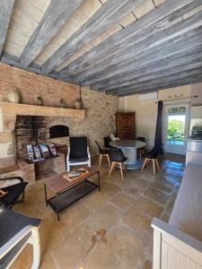 a living room with a fireplace and a table at Gîte L' authentique in Saint-Germain-des-Bois