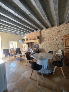 a room with a table and chairs and a brick wall at Gîte L' authentique in Saint-Germain-des-Bois
