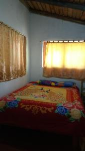 YanamaにあるHospedaje Illariyのベッドルーム1室(カラフルな毛布付きのベッド1台付)
