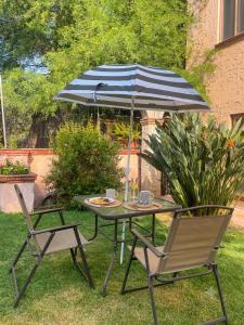 a table and two chairs with an umbrella at Casa Cantera in Tequisquiapan +1 photo