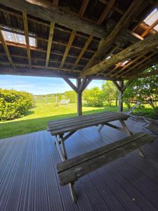 a wooden bench sitting on a wooden deck at Gîte L' authentique in Saint-Germain-des-Bois