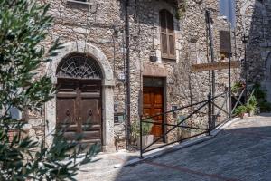 an old stone building with a wooden door and a staircase at B&B del pozzo in Narni
