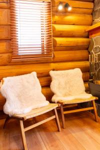 two chairs in a room with a wooden wall at Villa Rusutsu in Rusutsu