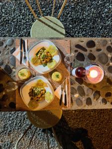 a table with two plates of food and a glass of wine at Morada Silvestre in La Peña