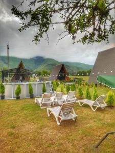 a group of lounge chairs sitting on the grass at Hillside Borjomi Two chalet in Borjomi