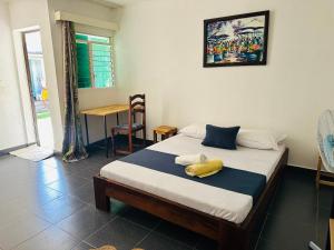 a bedroom with a bed with two towels on it at La Petite Maison in Antsiranana