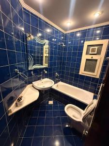 a blue tiled bathroom with a toilet and a sink at Porto Sokhna Aprtment Pool View - MR in Ain Sokhna +40 photos