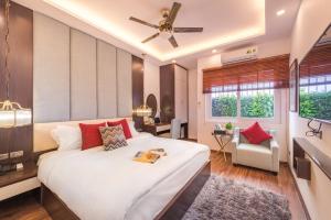 a bedroom with a large white bed with red pillows at Splendid Hotel & Spa in Hanoi