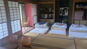 a room with four beds in a room with windows at Moon light stay in Nakatsugawa