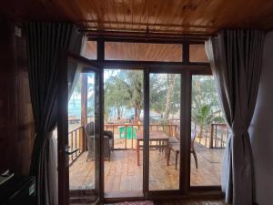 an open glass door to a deck with a table and chairs at Bai Thom Retreat in Phú Quốc +45 photos