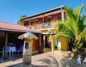 a house with a palm tree in front of it at Pousada dos Pescadores in Bertioga