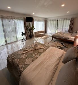 a bedroom with two beds and a room with windows at Kuba Bungalows in Ko Kood