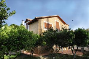 a brick house with trees in front of it at Villa Kaloudis in Kolymbia