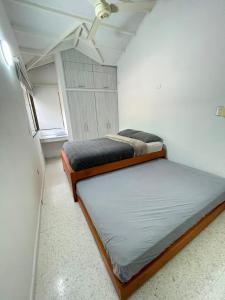 two beds in a small room with a window at 10 Caribe, tranquilidad y Casa Familiar in Rodadero
