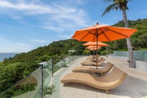 a row of benches with orange umbrellas on a balcony at Tanote Villa resort, Koh-Tao in Ko Tao