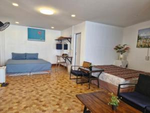 a bedroom with a bed and a couch and a table at Phahee valley ผาฮี้วัลเล่ย์ in Ban Ko Doi Tung
