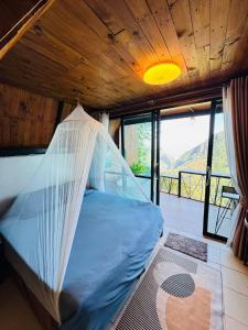 a bed with a net in a room with a view at Phahee valley ผาฮี้วัลเล่ย์ in Ban Ko Doi Tung