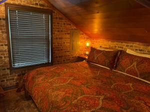 ein Schlafzimmer mit einem Bett und einer Ziegelwand in der Unterkunft VacationHouse in Ulster Park