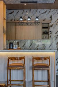 two chairs sitting at a bar in a kitchen at Junna House Ubud in Payangan