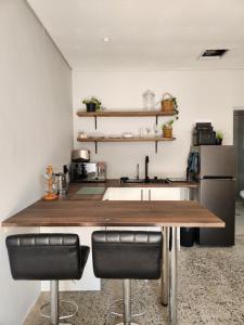 a kitchen with a counter with a sink and some chairs at Windsor Cottage in Avondale