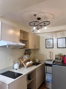 a kitchen with wooden cabinets and a sink and a ceiling at Davao Cozy Condo T6 unit 2 in Davao City