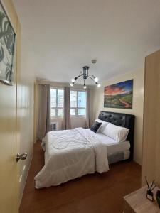 a bedroom with a large bed and a window at Davao Cozy Condo T6 unit 2 in Davao City