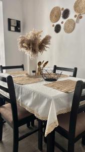 a dining room table with a white table cloth and a vase with flowers at The Embrace Luxury Villa - Hiriketiya in Dickwella