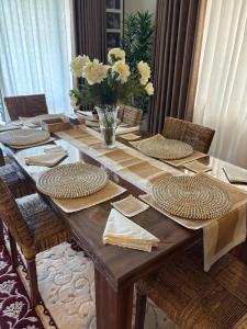 a wooden table with chairs and a vase of flowers at The Embrace Luxury Villa - Hiriketiya in Dickwella +45 photos