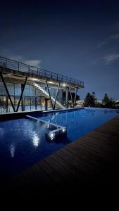 a swimming pool with a bridge and a building at The Hilltop Apartment in Guadalajara