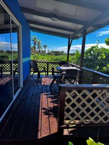 a deck with tables and chairs and a view of the ocean at Dream lodge in Rangiroa