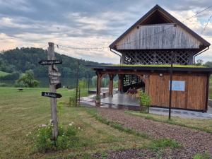 a wooden building with a sign in front of it at Lake window in Škofja Vas