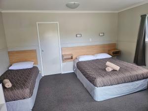 a hotel room with two beds and a mirror at Stratford Motel & Holiday Park in Stratford +37 photos