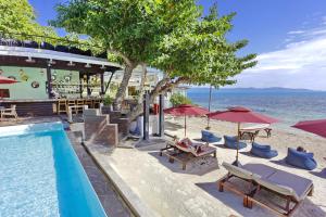 a resort with a swimming pool and chairs and umbrellas at Sunset Beach Hotel - Adults Only in Haad Rin