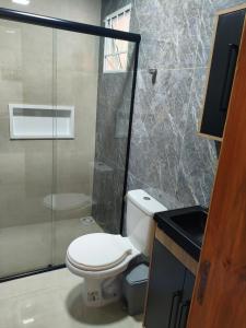 a bathroom with a toilet and a glass shower at Morada dos eucaliptos in Capão da Canoa +10 photos