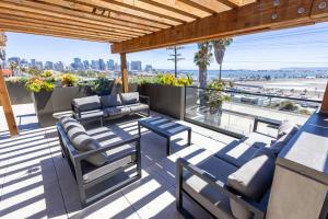 a patio with blue furniture and a view of the beach at City24 Condo Hotel Little Italy Mission Hills in San Diego