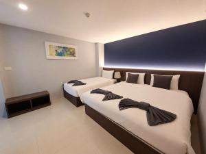 a hotel room with two beds with bow ties on them at The Seens Hotel in Krabi