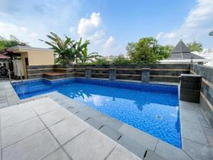 a swimming pool with blue water in front of a building at Alzetta Hotel by Abiza in Timuran