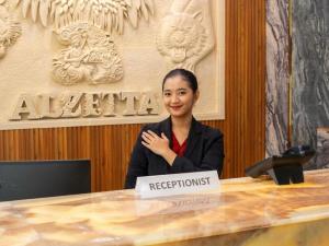 a woman sitting at a table with a registration sign at Alzetta Hotel by Abiza in Timuran