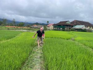 a man walking through a field of grass at Aluoi Homestay in Hue