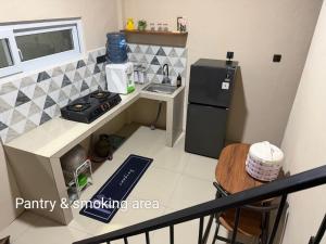 a small kitchen with a sink and a refrigerator at Gassania Hostel in Banda Aceh